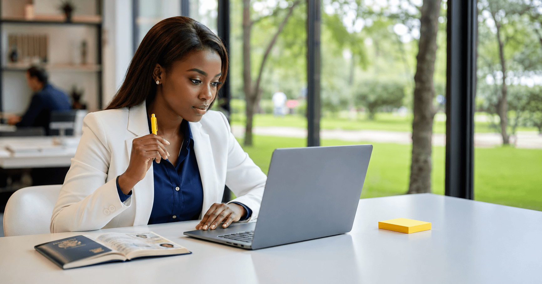 Confident traveler in white blazer researching best dummy ticket website on laptop at bright modern Nairobi co-working space with small yellow accent in 2026